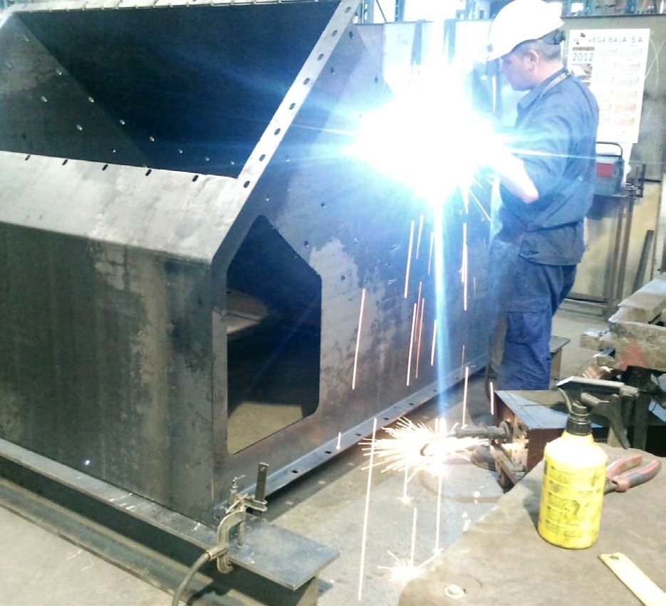 Soldador trabajando en un componente de estructura metálica